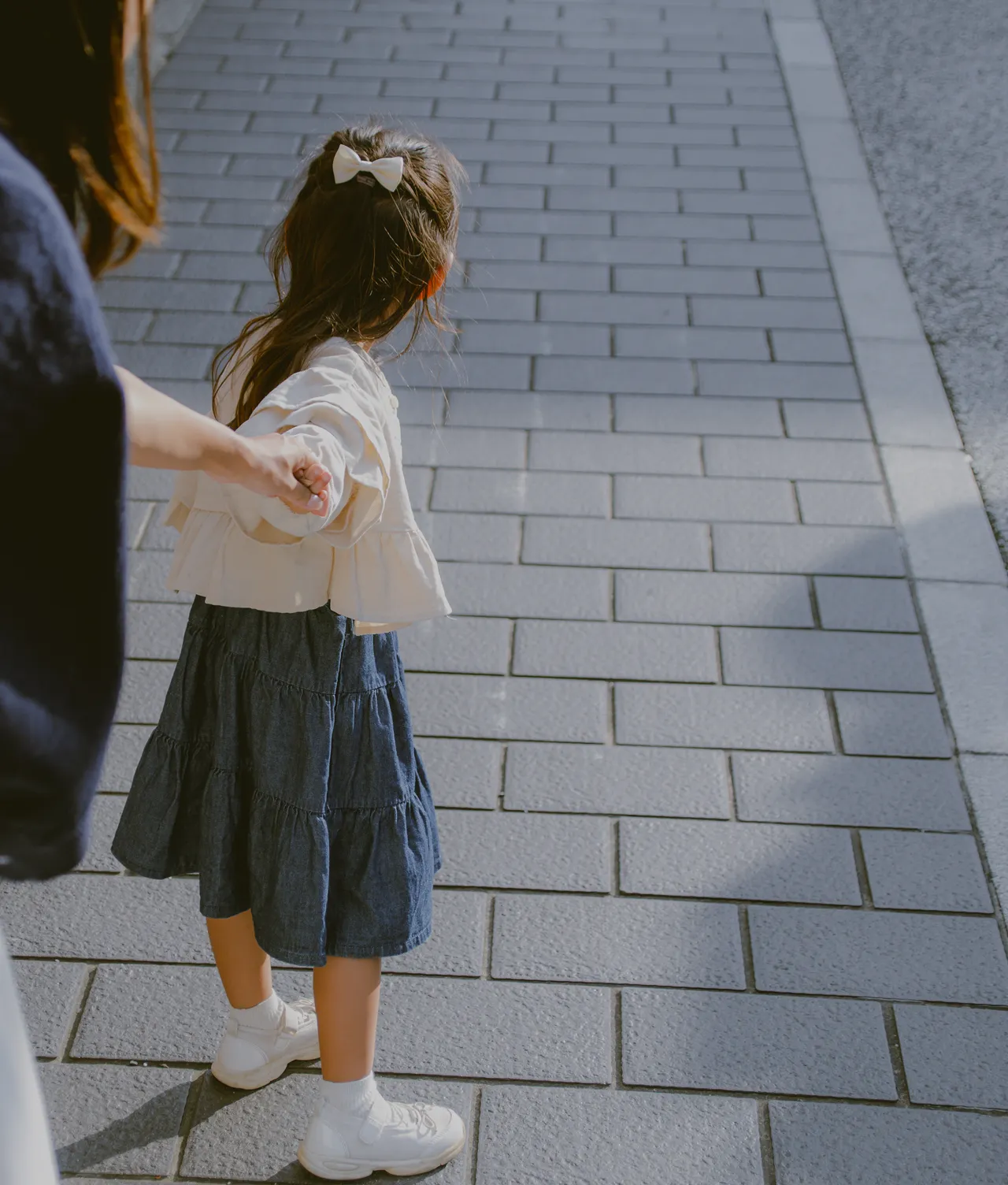 お母さんと手を繋いでいる女の子